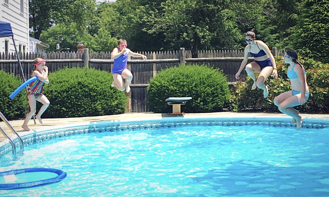 Family jumping in pool