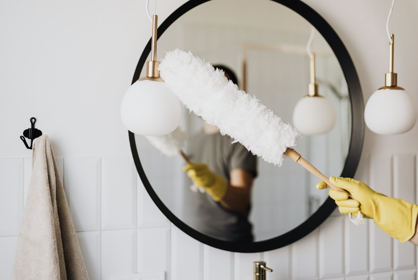 Short-term rental cleaner cleaning a mirror