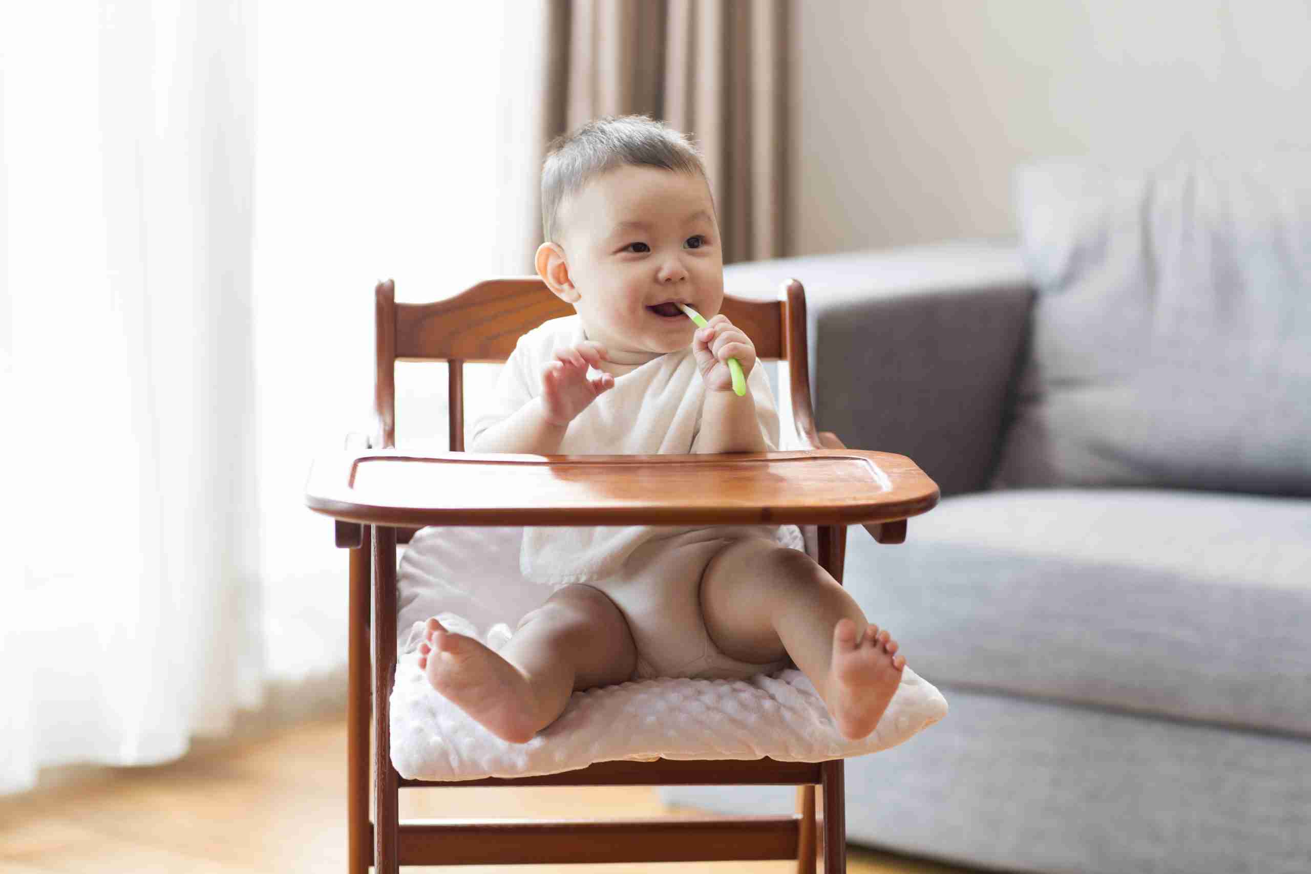 Cute baby boy sitting in high chair