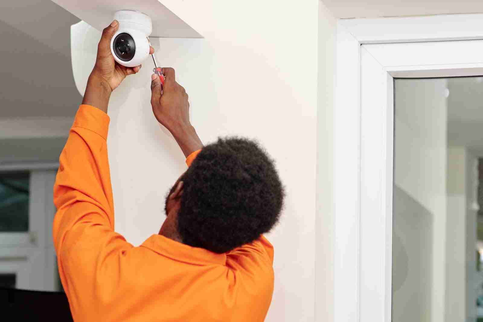 Man installing a security camera in his home