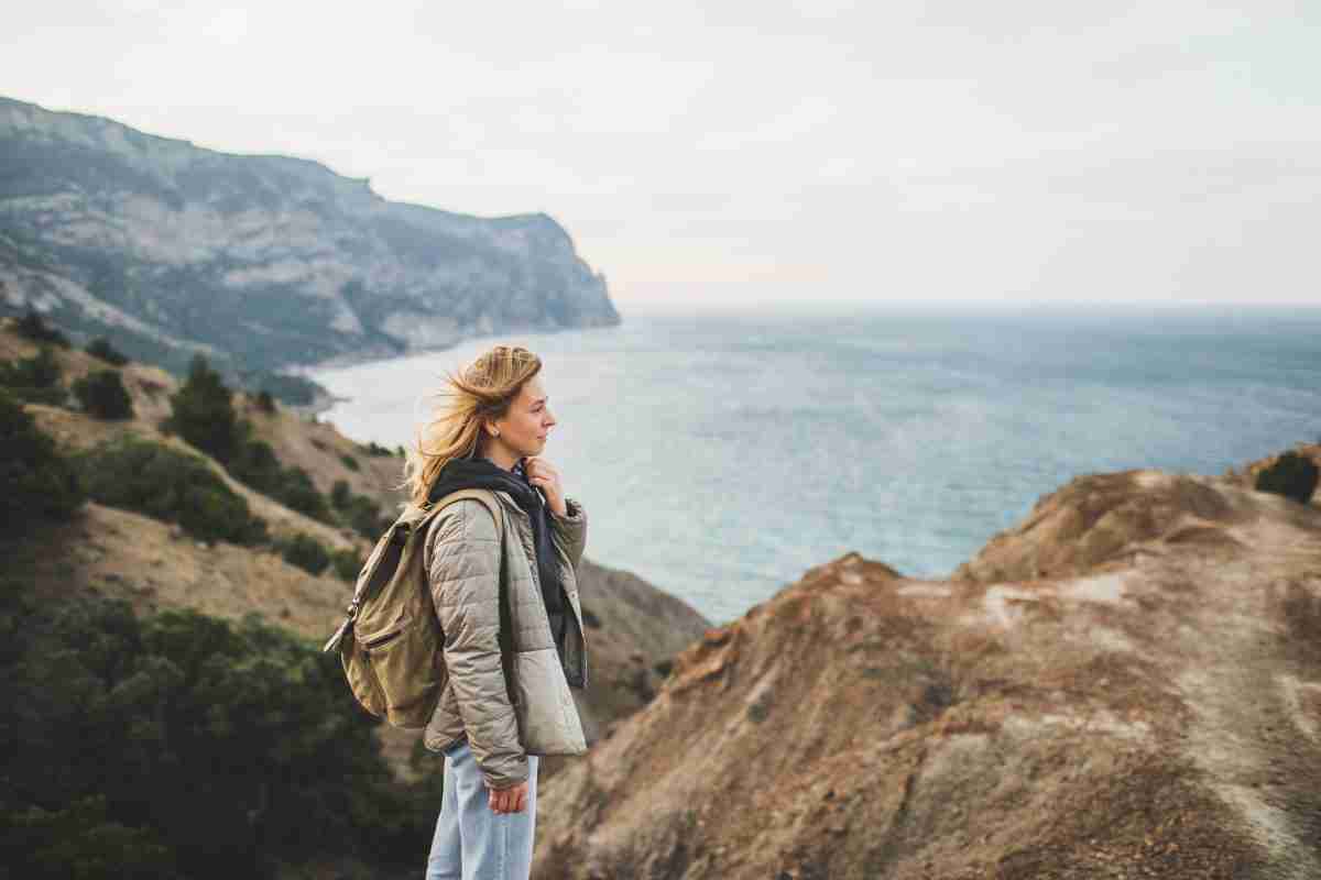 Happy young traveler woman walking and enjoying amazing coastlin