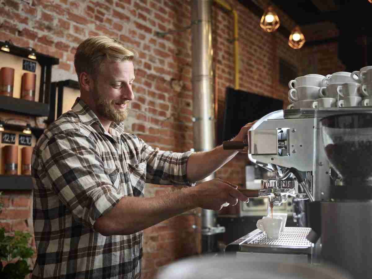 Man preparing espresso in a cafe with luxury airbnb amenities