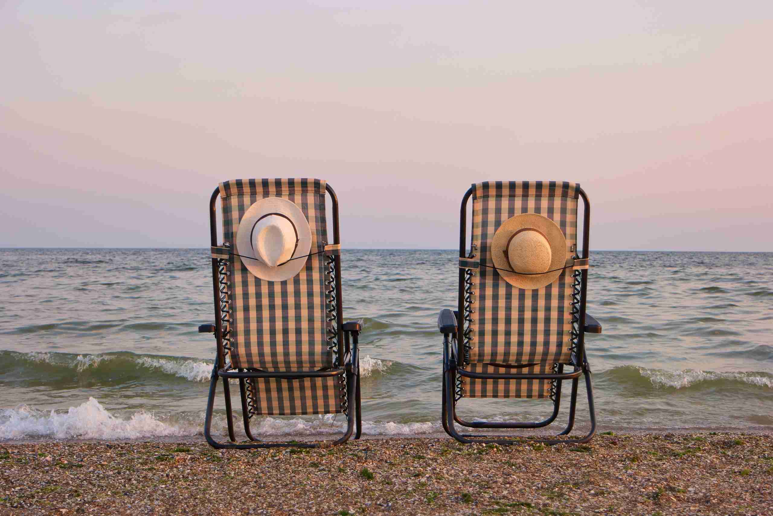 Rear view beach chairs on seashore.